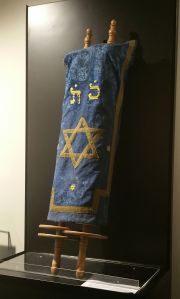 A ma, a múzeum központi helységében egy vitrinben elhelyezett, egy magyaroszági askenáz közösségtől származó Tóra szövegét tartalmazó, héber nyelvű pergamentekercset, amelyet két fatengelyre tekertek fel és díszes Tóratakaróval burkolták be, több mint 120 éves.A ma, a múzeum központi helységében egy vitrinben elhelyezett, egy magyaroszági askenáz közösségtől származó Tóra szövegét tartalmazó, héber nyelvű pergamentekercset, amelyet két fatengelyre tekertek fel és díszes Tóratakaróval burkolták be, több mint 120 éves.